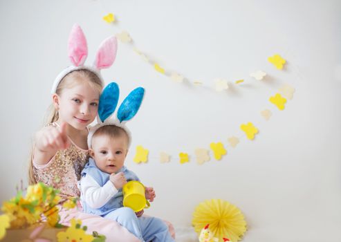 Two cute little children boy and girl wearing bunny ears in Easter decor