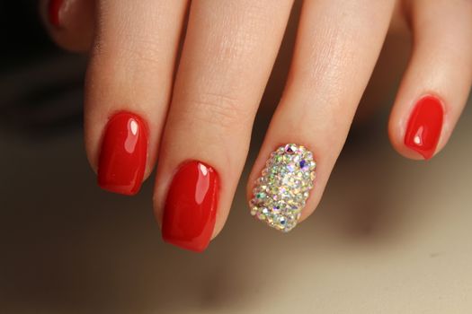 Manicure design gel varnish red nails with rhinestones