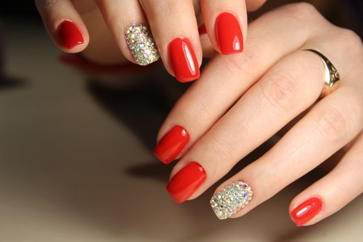 Manicure design gel varnish red nails with rhinestones