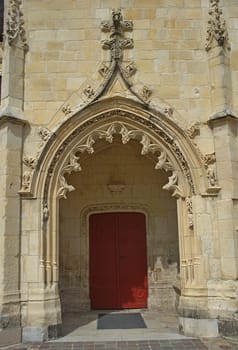 Entrance with red door at gothic style catholic church