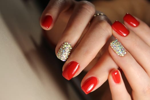 Manicure design nails is bright red and rhinestones