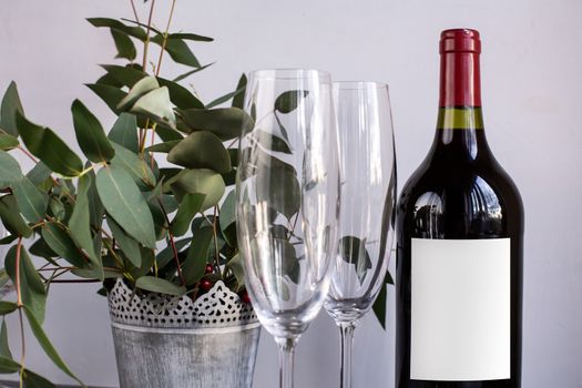 Composition with glass, flowers and bottle of vine on grey concrete background