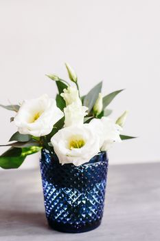 White flowers in classic blue glass. Lisianthus. Eustoma.