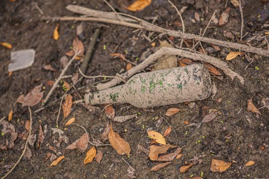 Glass bottle on the ground in a natural place