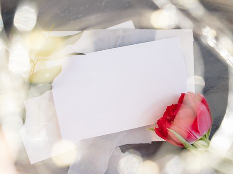 Blank paper copy space. Frame with flowers. Silk ribbon. Gray background. Simple bouquet. Greeting card