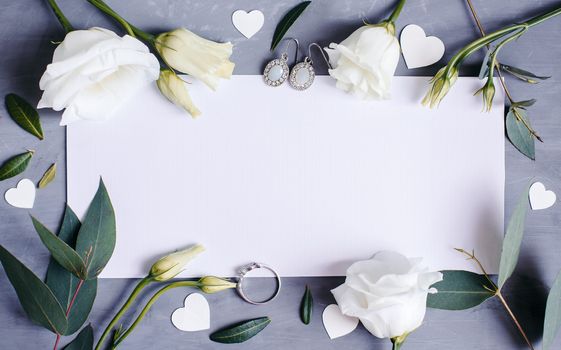 Blank paper copy space. Frame with flowers. Silk ribbon. Gray background. Simple bouquet. Greeting card