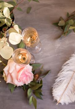 Composition with glasses of vine and flowers on grey concrete background