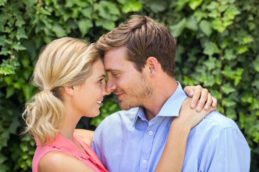 Romantic couple looking at each other while hugging in front yard