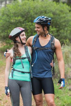 Romantic couple looking at each other while standing in forest