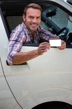 Portrait of young man showing his drivers license
