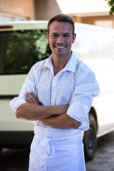Portrait of delivery man standing in front of his van