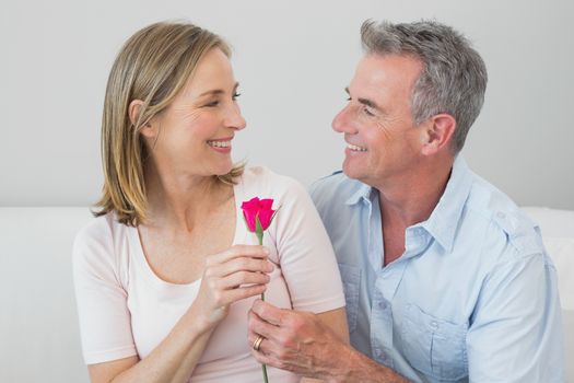 Happy romantic couple with a flower at home