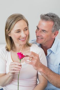 Happy romantic couple with a flower in the living room at home