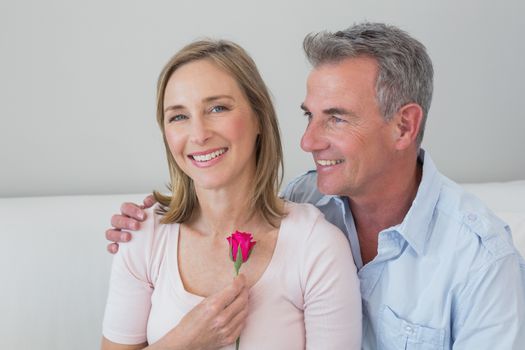 Portrait of a happy romantic couple with a flower at home