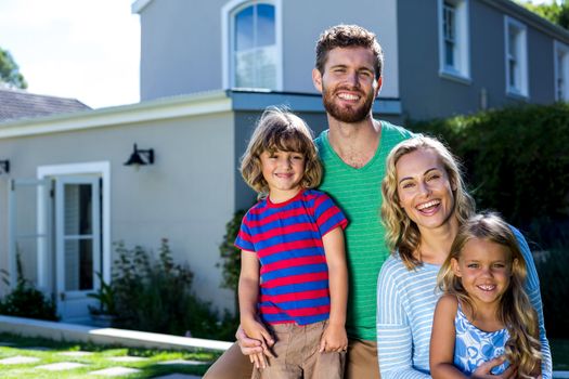 Portrait of cheerful family against house