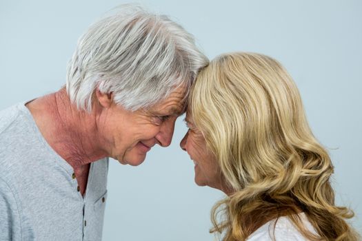 Close-up of romantic senior couple against wall at home