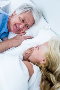 Romantic senior couple sleeping on bed in bedroom