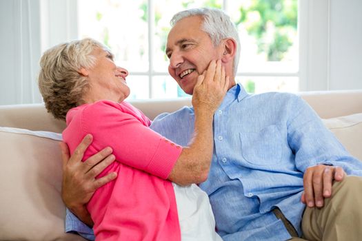 Romantic senior couple sitting on sofa at home