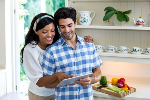 Young couple using digital tablet in the kitchen