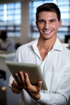 Portrait of young man using digital tablet in office