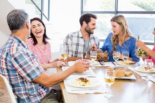 Friends interacting while having a meal at dining table