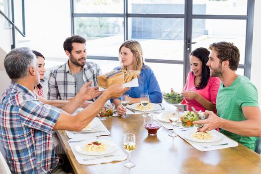 Friends interacting while having a meal at dining table
