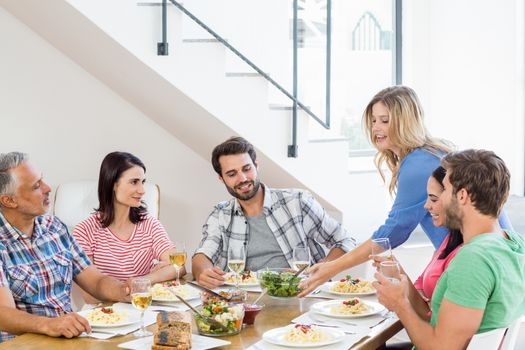 Happy friends having meal together at home