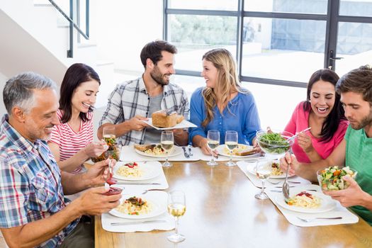 Friends interacting while having a meal at dining table