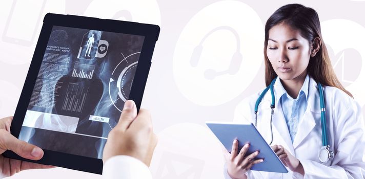 Asian doctor using tablet against medical icons