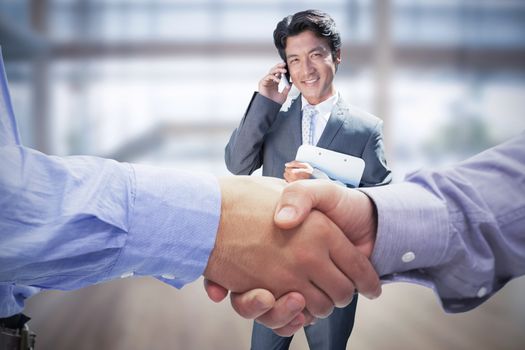 Composite image of two men shaking hands in office