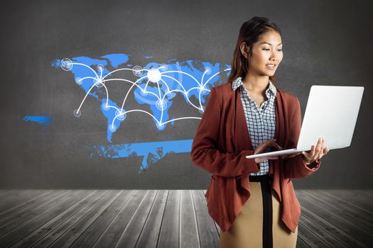 Smiling businesswoman using laptop against splash on wall revealing technology interface