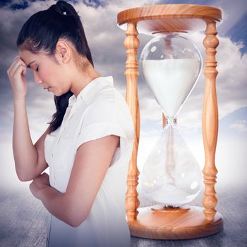 Casual upset businesswoman with head bowed against cloudy sky