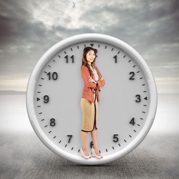 Smiling businesswoman with crossed arms against grey sky