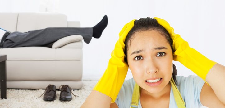 Stressed out woman against low section of a businessman resting on sofa in living room