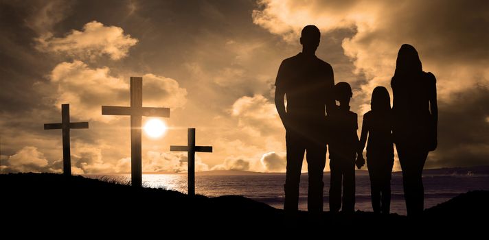 Cheerful family holding hands against cross religion symbol shape over sunset sky 