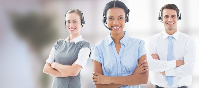 Portrait of call center executives standing with arms crossed against sofa chair in the office 