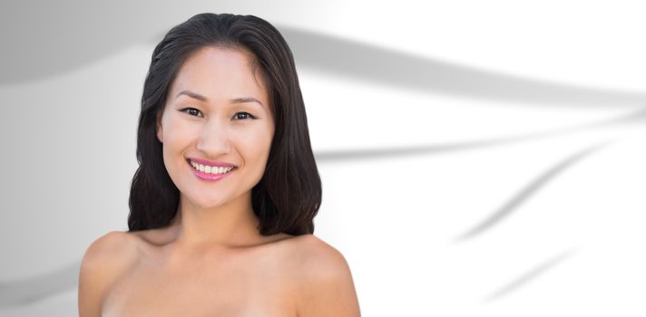 Smiling sensual nude brunette posing against white wave design