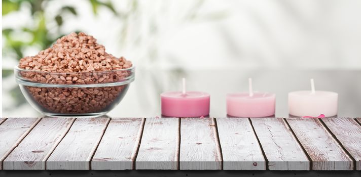 Wooden table against three pink aromatherapy candles