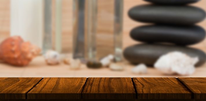 Wooden desk against stack of pebbles with beauty products