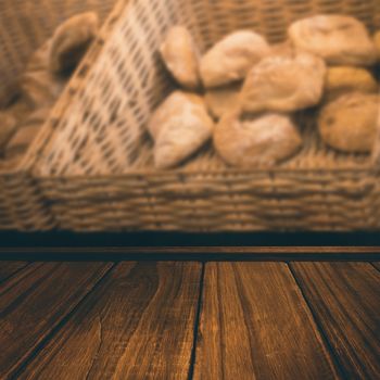 Close-up of wooden flooring against baskets with fresh and delicious breads