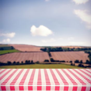 Red and white tablecloth against country scene
