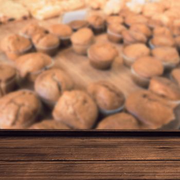 High angle view of wooden flooring against close up of muffins on counter