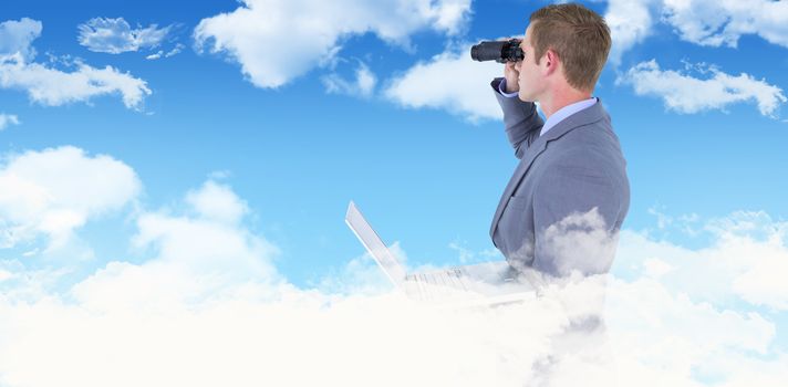 Businessman using binoculars against blue sky
