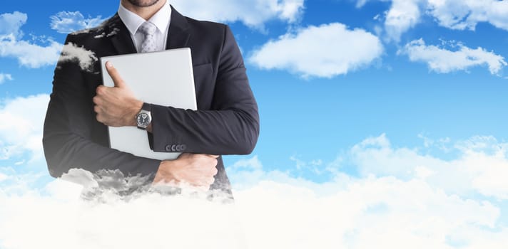 Mid section of businessman holding computer  against blue sky