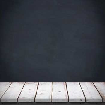 Wooden table against blackboard