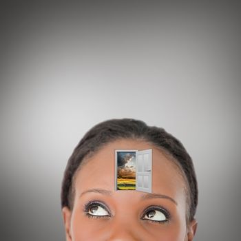 Close up of woman looking upwards diagonally with a door on her forehead