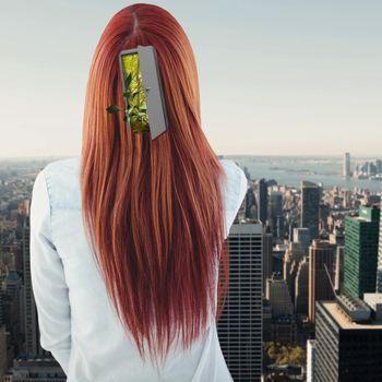 Rear view of hipster woman looking post-it against city skyline