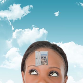 Close up of woman looking upwards diagonally on white background against blue sky