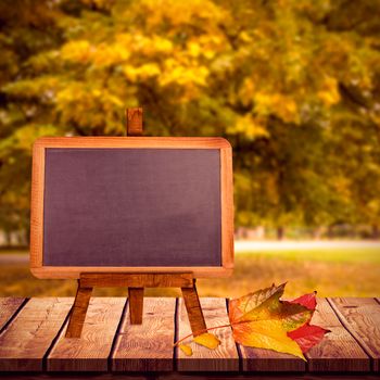 Image of a blackboard against large tree on meadow in the park