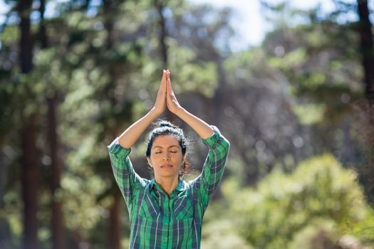 Attractive woman doing yoga in the wood